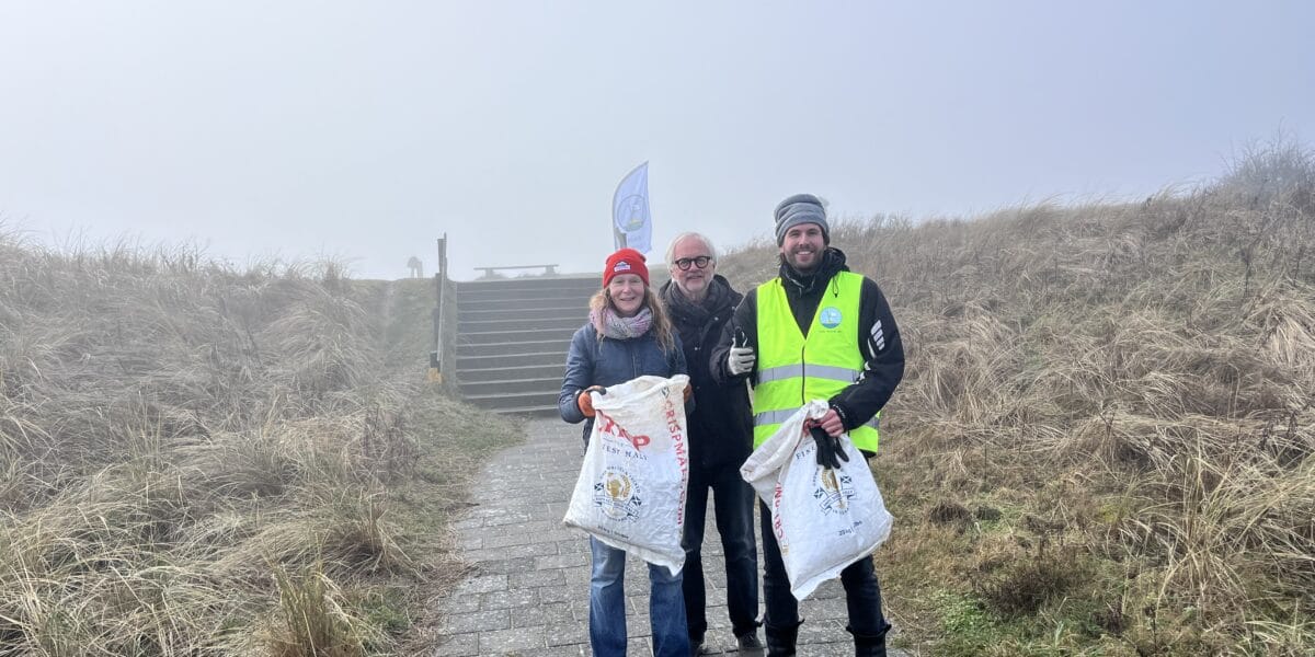 Jutters bij de Mokbaai met een afvalzak in de hand